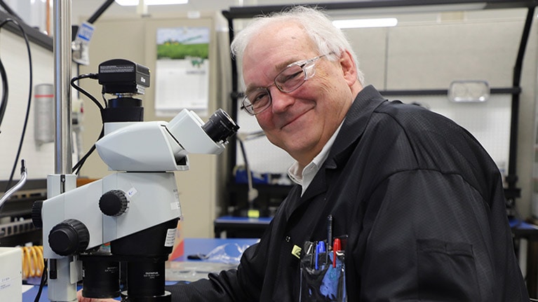 Dr. William F. Cooper, som sitter ved et mikroskop