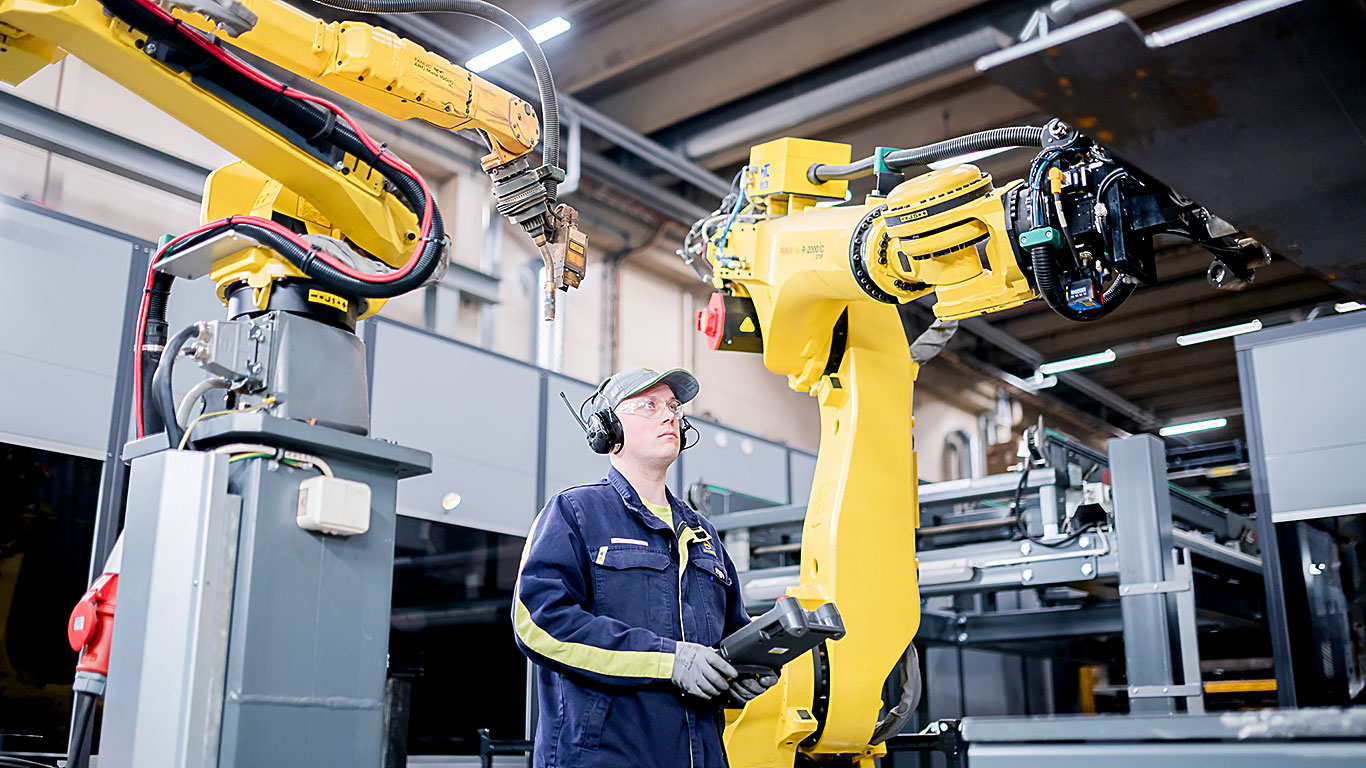 Jarkko Tuononen styrer en robot ved fabrikken