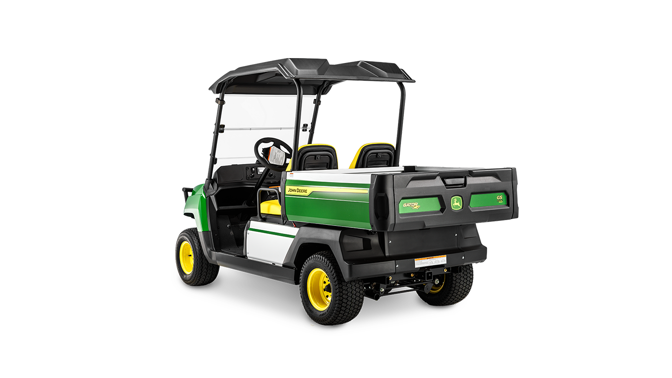 Bakovervinklet visning av en John Deere Gator GS bensinmodell som viser lasteplan, doble seter og beskyttende tak.