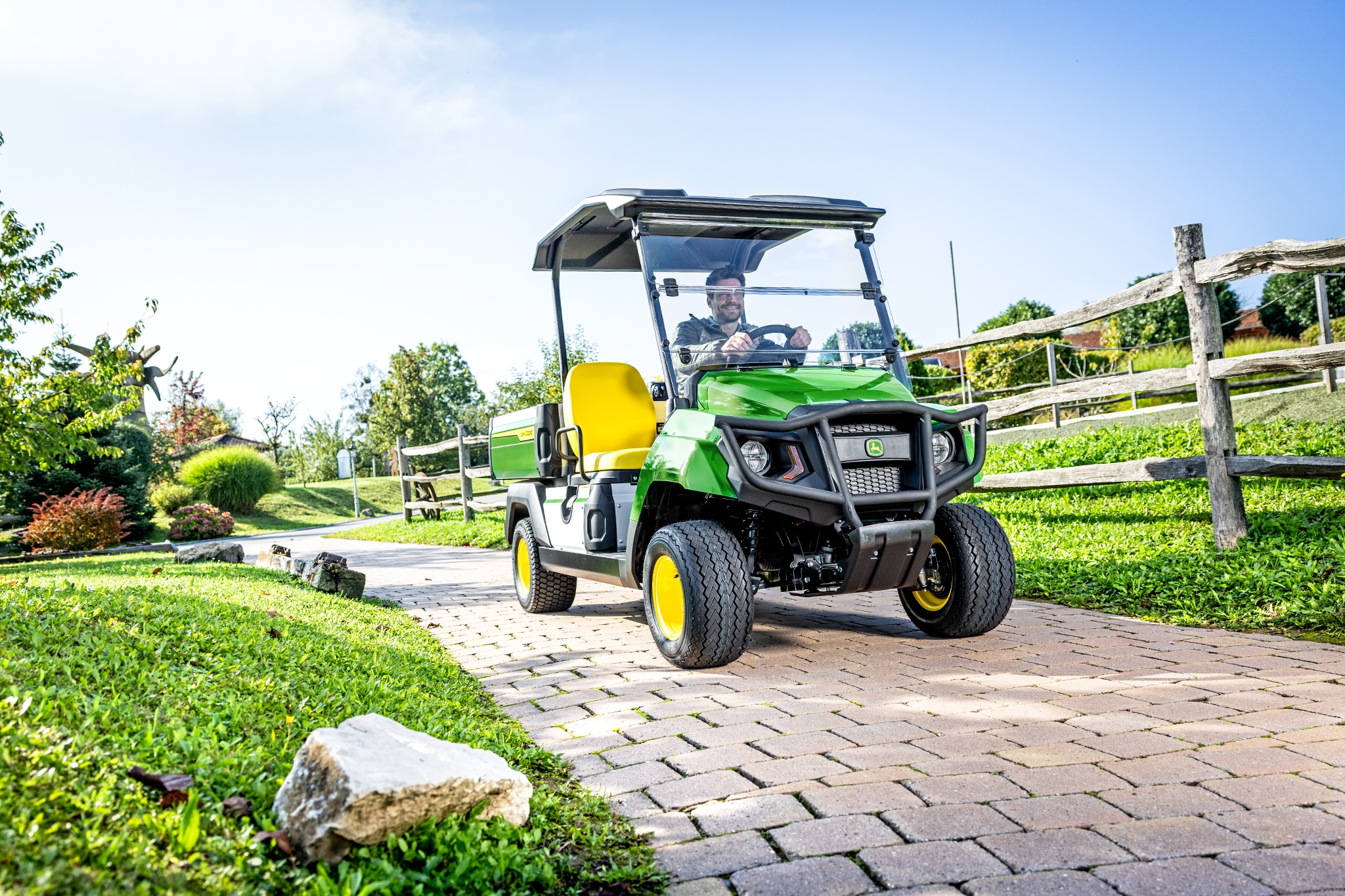 Gator GS nyttekjøretøy kjører på en asfaltert vei i et anlagt område