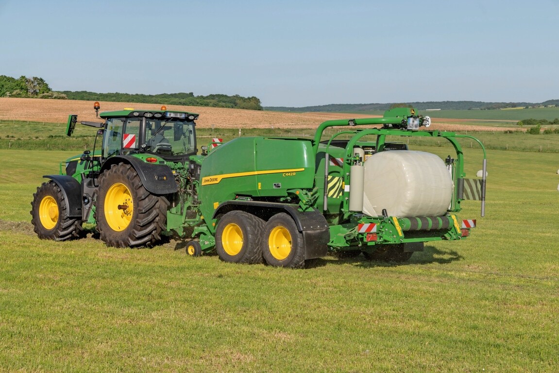 John Deere C442R-ballepakkeren trukket av en John Deere 6R 185 som lager høydensitets siloballer