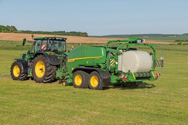 John Deere C442R-ballepakkeren trukket av en John Deere 6R 185 som lager høydensitets siloballer